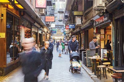 Busy laneway with cafes and people walking through