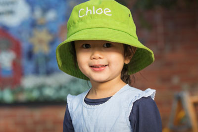 A young girl wearing a hat labelled 'Chloe'