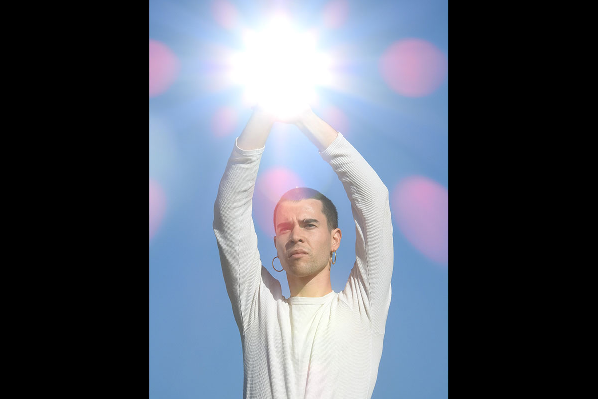 Man with upraised hands obscured by glowing orb