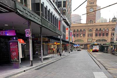 Completed works on Elizabeth Street near Flinders Street Station showing bluestone paving between the footpath and tram stop.
