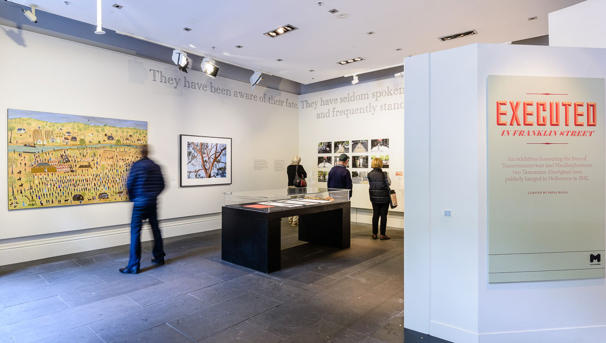 A gallery where people look at artworks mounted on the walls.