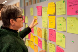 a lady working with post-its on a wall