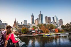 People looking across Yarra River with city in background