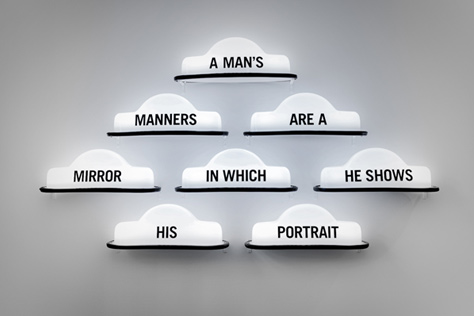 Close-up of taxi light signs spelling out 'A man's manners are a mirror in which he shows his portrait'
