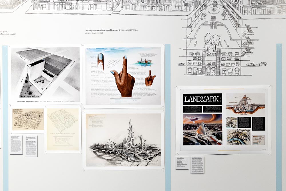 Closer view of the maps and plans of unusual structures, including a glass pyramid and a hand with finger pointing upwards.