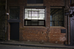 Red brick building facade with image projected onto window