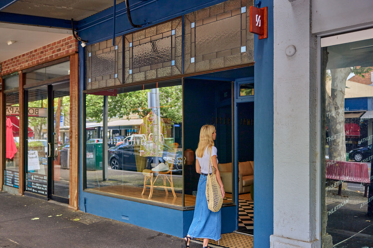 The Joseph and James shopfront window with a woman standing in the door way of the image.