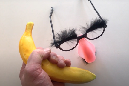 Groucho Marx mask and hand holding a banana