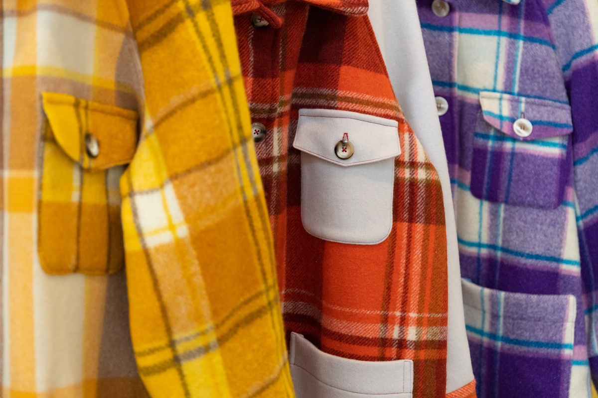 Three different jackets, one in yellow, orange and white and purple checkered.