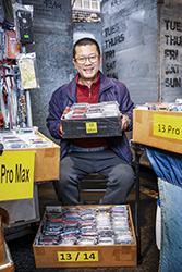 Smiling man sitting with boxes of mobile phone cases