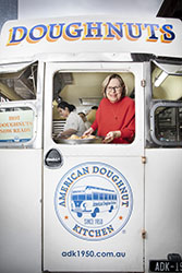 Smiling woman looking out window of white donut van
