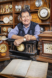 Smiling man with vintage clocks