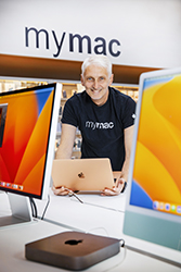 Smiling man holding a laptop