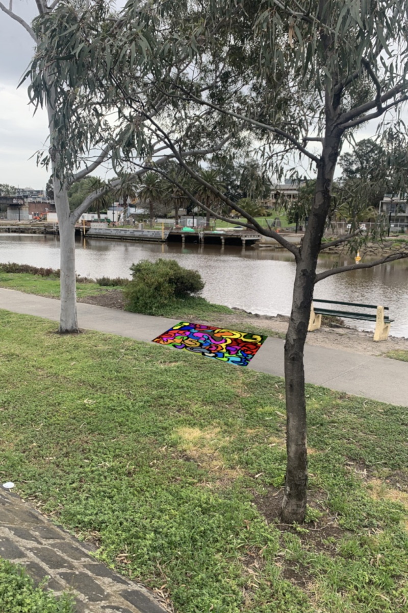 A footpath near the Yarra River showing a bright painting over a section of the concrete.