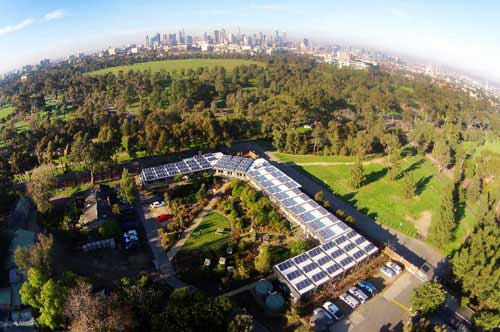 Extreme wide-angle aerial view of Melbourne Zoo showing surrounding parkland and city skyline in the background