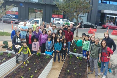 Southbank Sustainability Group members posing among raised garden beds