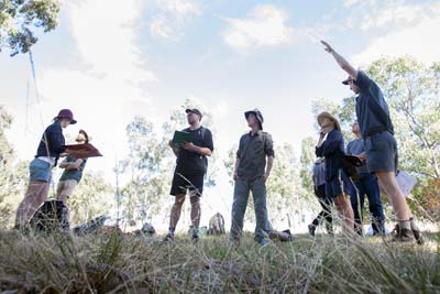 Group of people examining trees in bushland