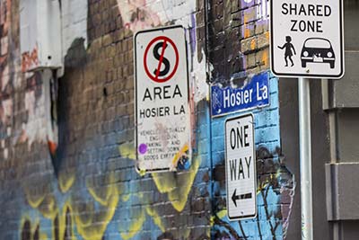 Signs for no stopping, shared zone and one way in Hosier Lane.