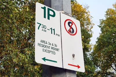 Parking sign indicating 1P to the left (except for resident permit holders) and a No Stopping area to the right.