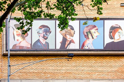 Artwork of people's faces decorating a brick wall