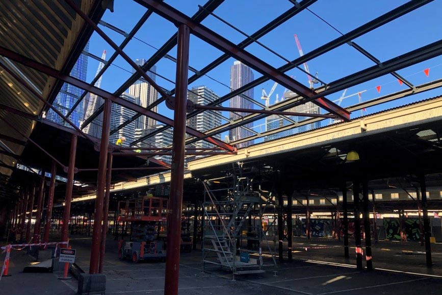 CBD high rise buildings seen through roof frame structure of the QVM shed.