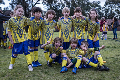 Muddy kids in sports uniforms