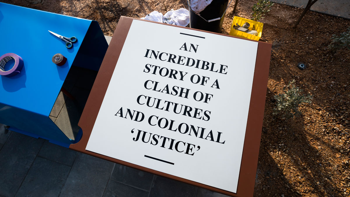 A sign saying 'An incredible story of a clash of cultures and colonial 'justice'.
