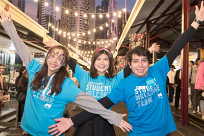 Three smiling people wearing t-shirts that read Student Welcome Team.