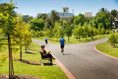 People jog and sit in a park.