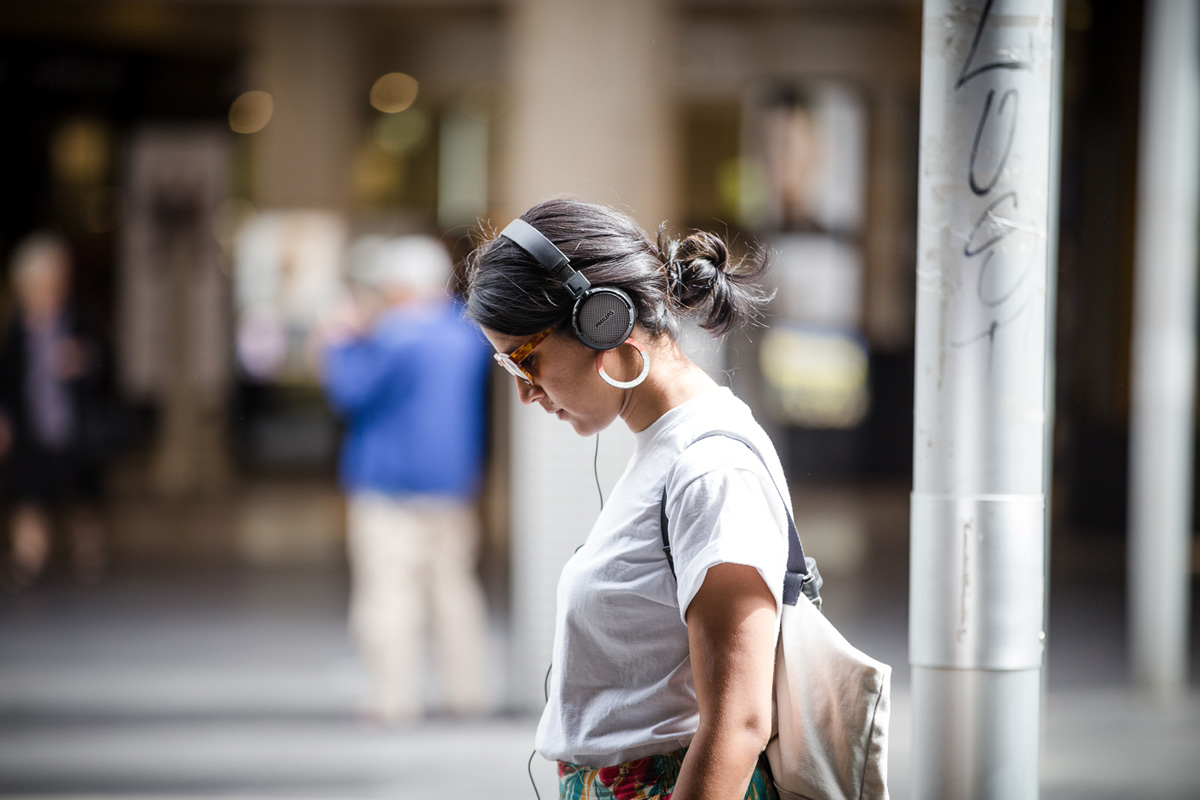 Person on city street listening to headphones