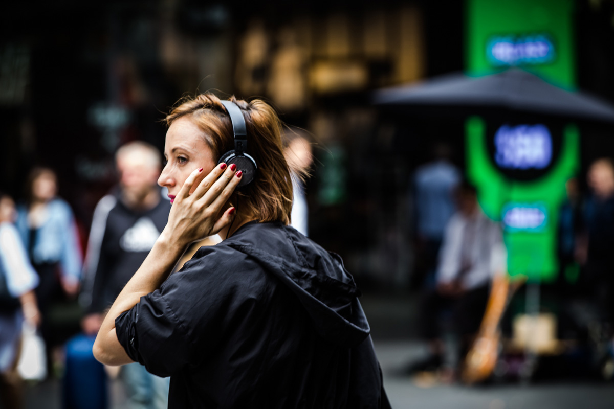 Person on city street listening to headphones
