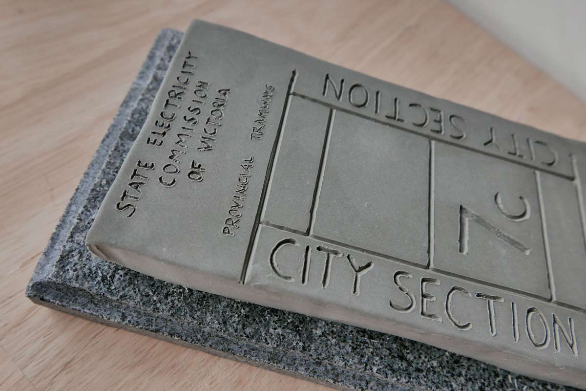 Close up of a scultpure of a ticket on a marble base, inscribed with the words 'State Electricity Commission of Victoria, Provincial Tramways, City Section 7c'