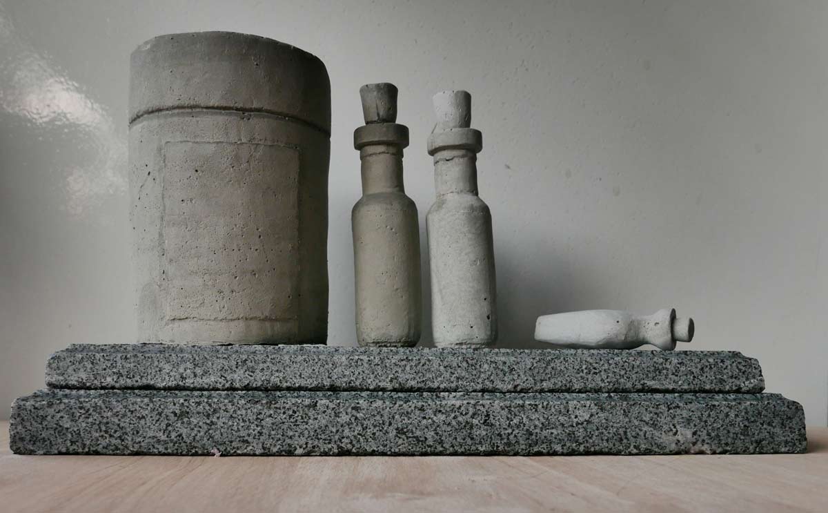 Cement sculptures of pharmecutical bottles and jars, on a marble plinth