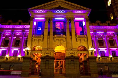 Melbourne Town Hall at night, lit with purple lights