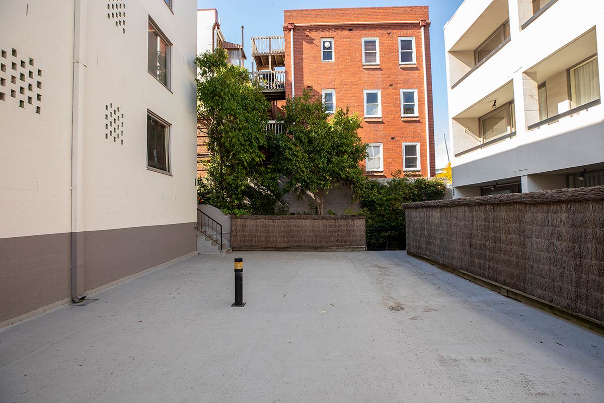 Bare concrete area between apartment buildings.