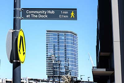 A sign for Community Hub at the Dock with details of distance and walking time