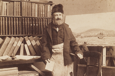 sepia toned historical image of William Legrand, bookseller, in his Hobart shop, after 1891